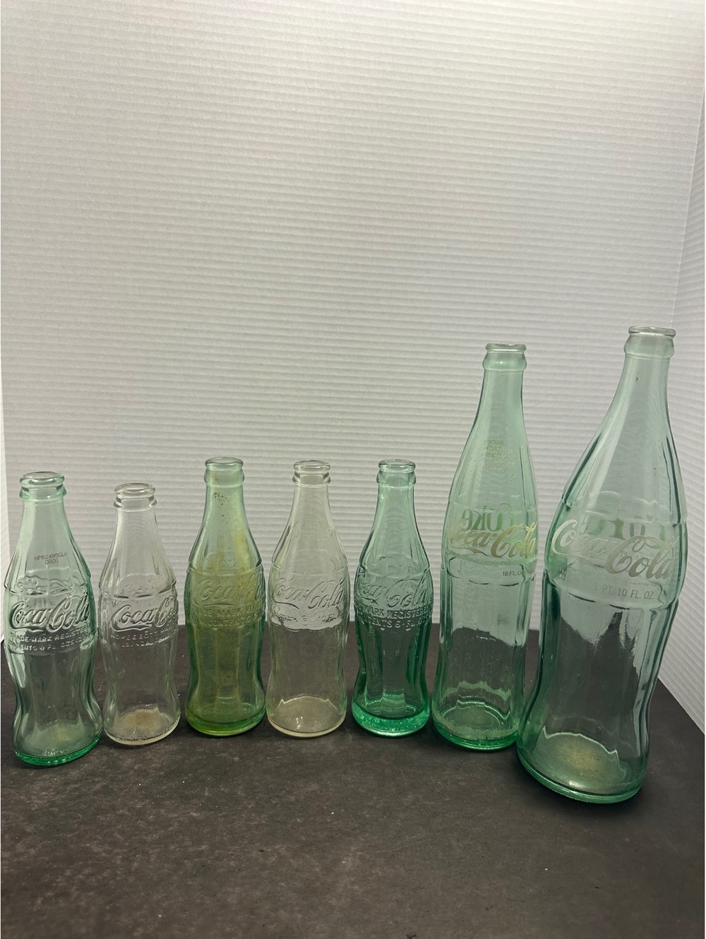 7 vintage Coca Cola glass bottles embossed green clear mixed sizes lot
